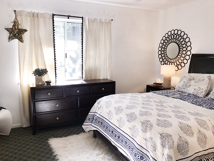 blue and white guest room with dark wood furniture