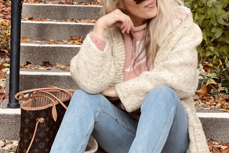 80s look with faded washed high waste jeans and vintage dusty rose mauve 80s sweater with ivory leaves for fall, a louis vuitton neverfull bag, fall style over 40, by lake arrowhead at sunset