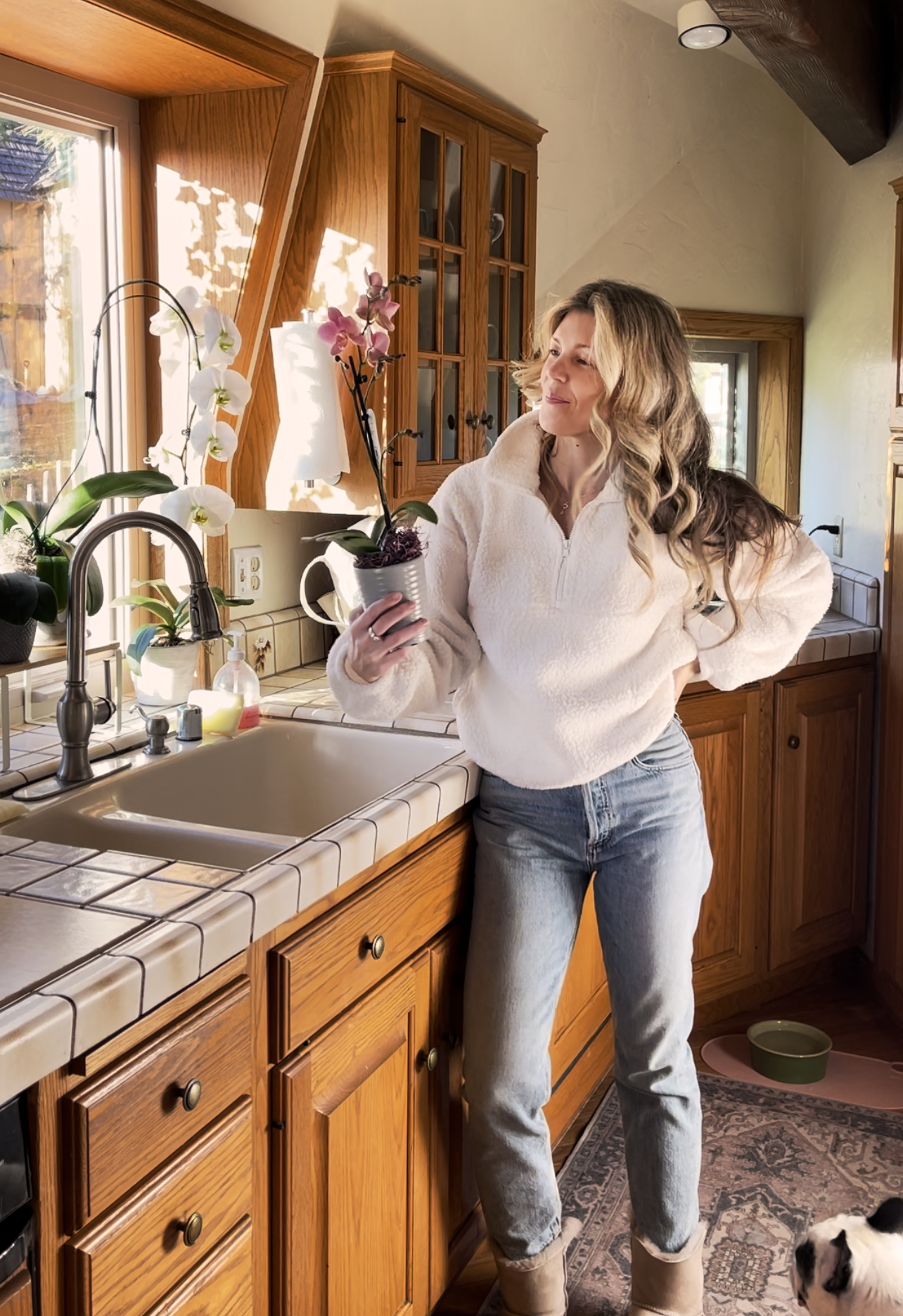 holding a pink orchid in 80s kitchen in dome house