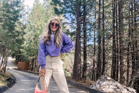 colorful spring outfit with ivory coveralls jumpsuit with lavender cropped sweatshirt pink prada nylon bag and nike sky hi