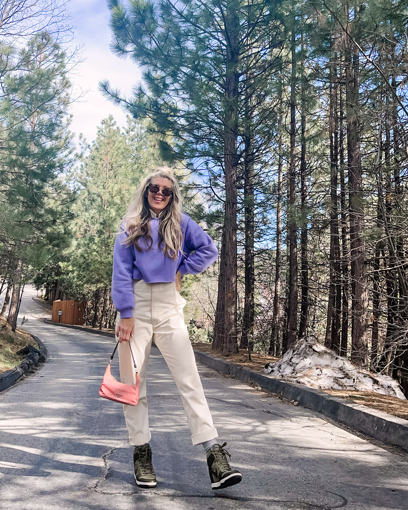 cute spring style in coveralls, lee jeans union-alls jumpsuit in ivory with lavender cropped sweatshirt, pink prada bag and nike sky high sneakers