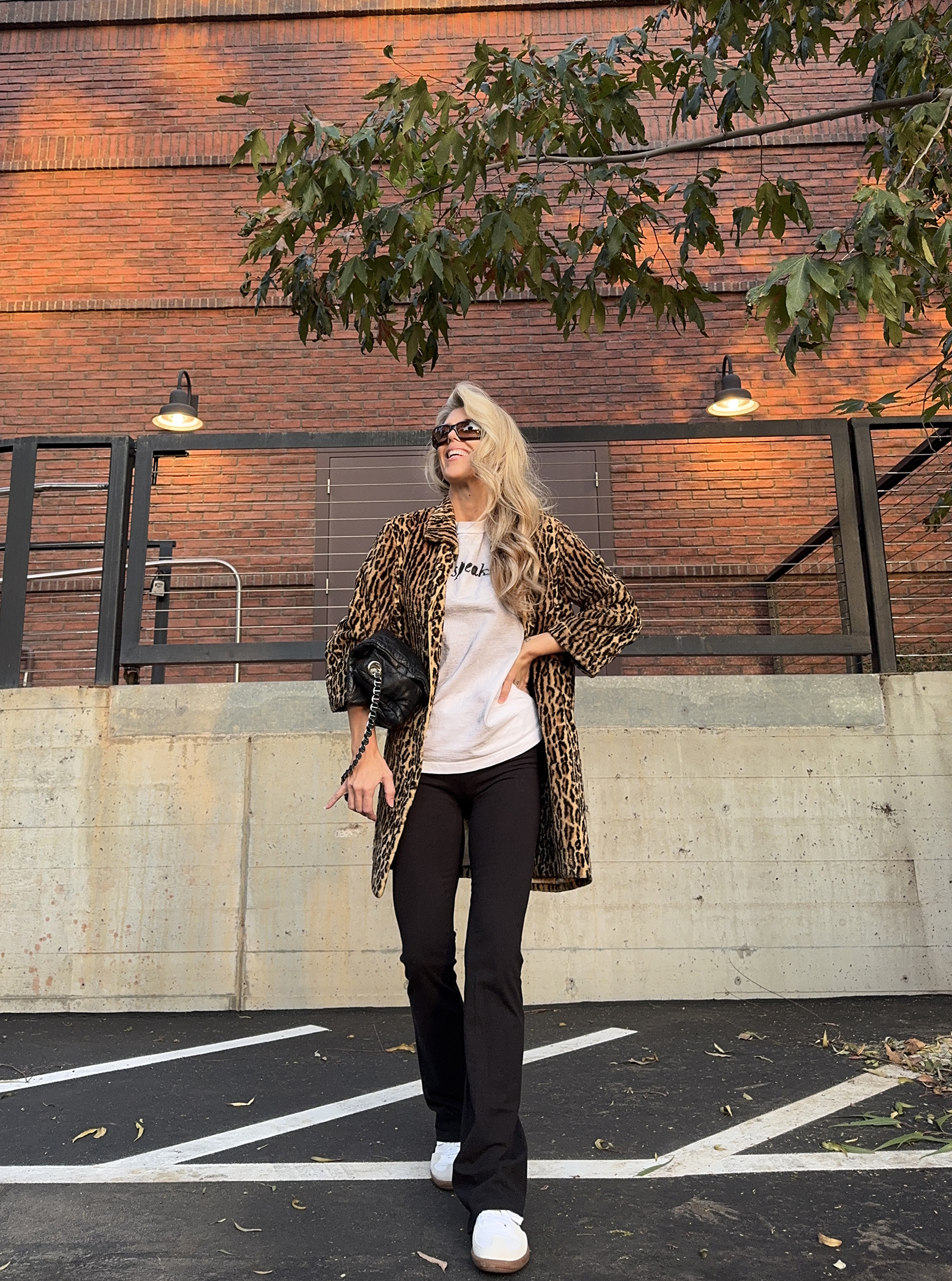 casual fall style with flared black pants leggings, puma sneakers and a leopard coat, mixed styles and fashion trends with athleisure mixed with cocktail, fall 2024 style