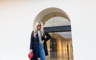 cloudy sky at dusk-spring style-wide leg jeans-white sneakers-striped top-military jacket-long blonde hair